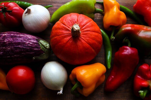 Frische rohe Kürbispaprika-Chili-Paprika-Tomaten-Zwiebeln und Auberginen-Gemüse-Hintergrund