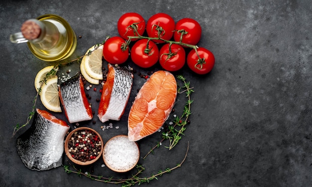 frische rohe Lachssteaks und Lachsschwanz mit Salz, Pfeffer, Tomaten, Zitrone