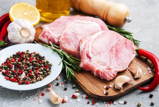 Foto frische rohe schweinekotletten mit gewürzen und kräutern