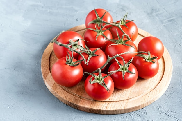 Frische rohe und schöne Traubentomaten zur Verwendung als Kochzutaten Tomaten auf Holzbrett