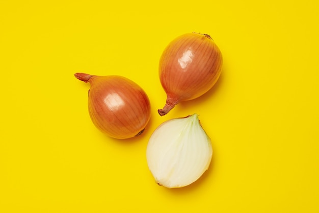 Frische rohe Zwiebel auf gelbem Hintergrund, Draufsicht