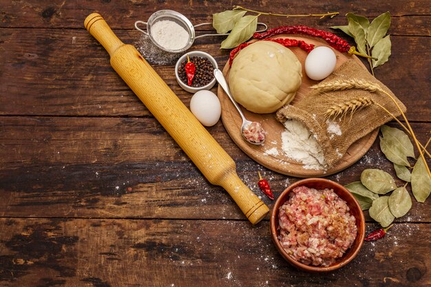 Frische Rohstoffe für die Zubereitung von Knödeln, Ravioli, herzhaften Kuchen, Quiche. Füllung, Mehl, Teig, Eier, Gewürze