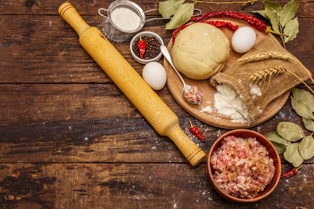 Frische Rohstoffe für die Zubereitung von Knödeln, Ravioli, herzhaften Kuchen, Quiche. Füllung, Mehl, Teig, Eier, Gewürze