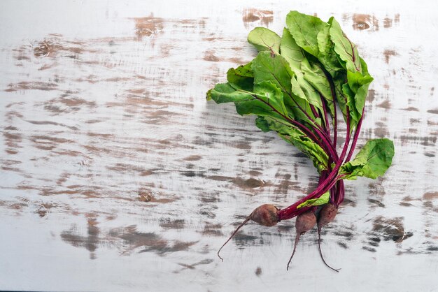 Frische rote beete mit grünen blättern auf einem hölzernen hintergrund draufsicht kopieren sie platz