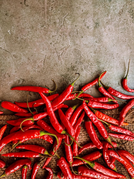 Frische rote Chilischoten auf Vintage-Stoffhintergrund.