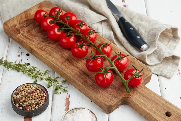 Frische rote Kirschtomaten auf weißem Holzhintergrund