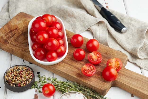 Frische rote Kirschtomaten auf weißem Holzhintergrund