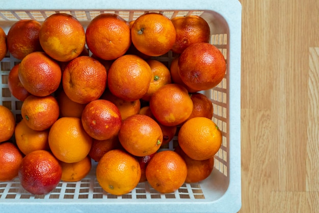 frische rote Orangen in Plastikkiste Draufsicht b