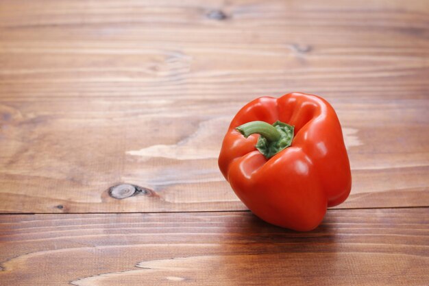 Frische rote Paprika auf einem braunen Holztisch