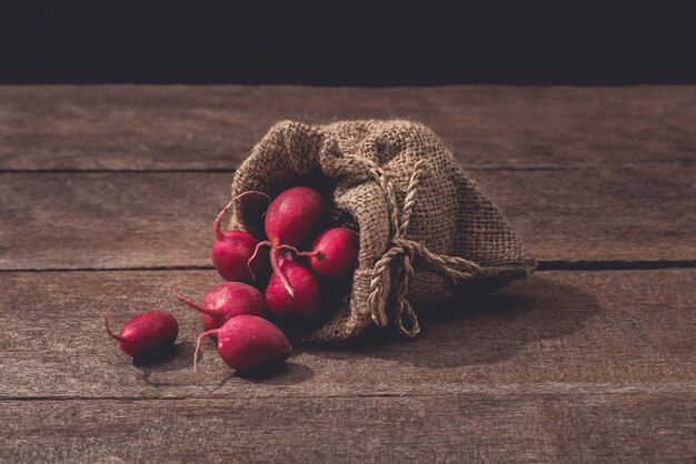 Frische rote Rettiche auf Holztisch