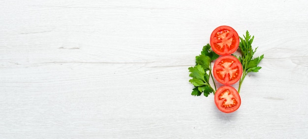 Frische rote Tomaten auf weißem Hintergrund aus Holz Grüne Ansicht von oben Freier Platz für Ihren Text