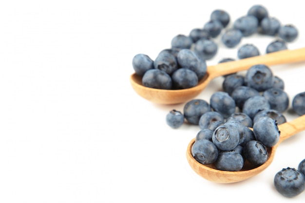 Frische saftige Blaubeerfrüchte auf einem Holzlöffel isoliert