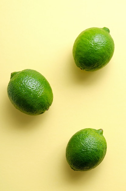 Foto frische saftige limetten auf gelber oberfläche