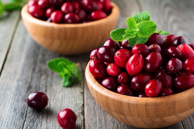 Frische saftige Preiselbeeren in einer Bambusschale auf der alten Holzoberfläche. Selektiver Fokus.