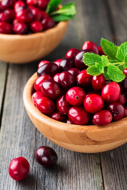 Frische saftige Preiselbeeren in einer Bambusschale auf der alten Holzoberfläche. Selektiver Fokus.