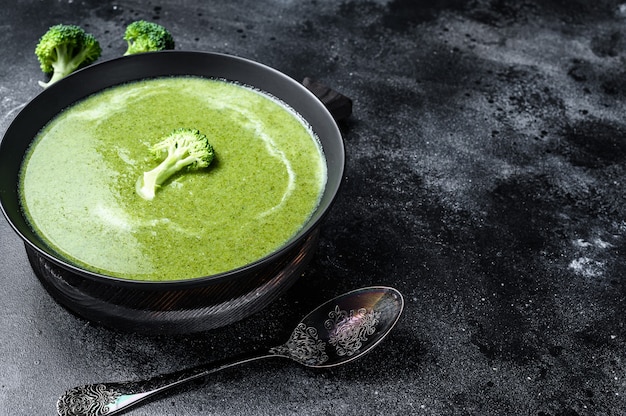 Frische Sahne Brokkoli und Erbsensuppe in Teller. Schwarzer Hintergrund. Draufsicht. Speicherplatz kopieren.