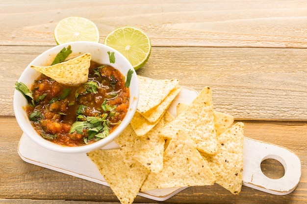 Frische Salsa in weißer Schüssel mit weißen Maistortilla-Chips.