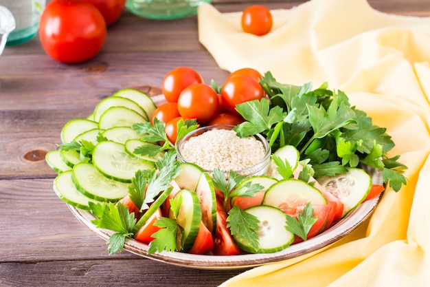 Frische Scheiben Gurken, Tomaten und Petersilienblätter auf einem Teller