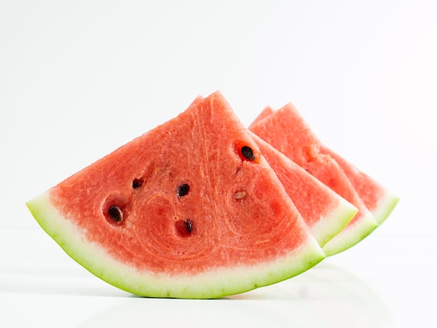 Frische Scheiben Wassermelone auf weißem Hintergrund.