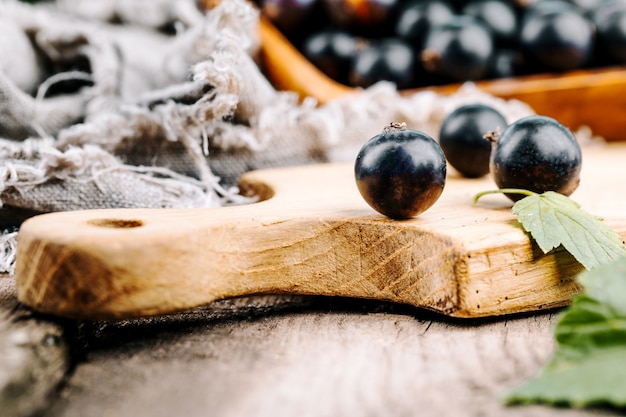 Frische schwarze Johannisbeere. Eine Handvoll Beeren auf einem Holztisch.