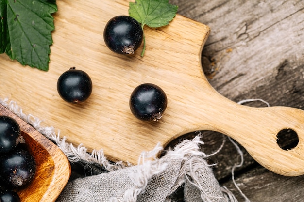 Frische schwarze Johannisbeere. Eine Handvoll Beeren auf einem Holztisch.