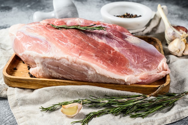 Frische schweinefleischstücke. rohes fleisch mit gewürzen. hinterbeinsteak. grauer hintergrund. ansicht von oben