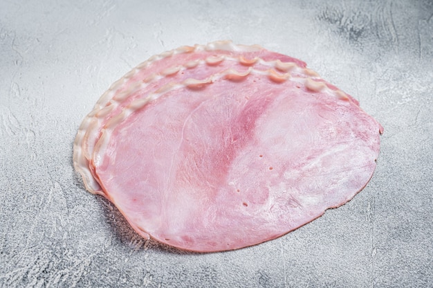 Frische Schweineschinkenscheiben auf dem Küchentisch. Weißer Hintergrund. Ansicht von oben.