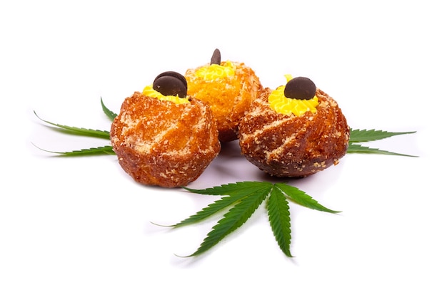 Frische süße Backwaren mit Marihuana, drei Cupcakes mit Cannabispflanzenblättern lokalisiert auf weißem Hintergrund, Süßigkeiten, Nachtisch.