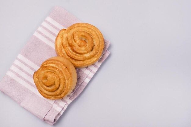 Frische süße hausgemachte Zimtschnecken auf rosa Serviettenplatz für Text