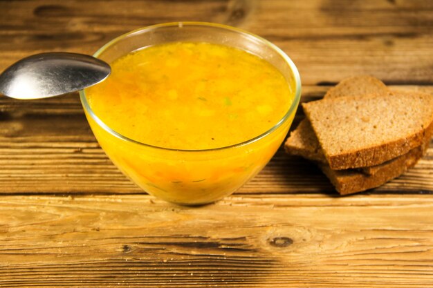 Frische Suppe in Glasschüssel auf Holztisch