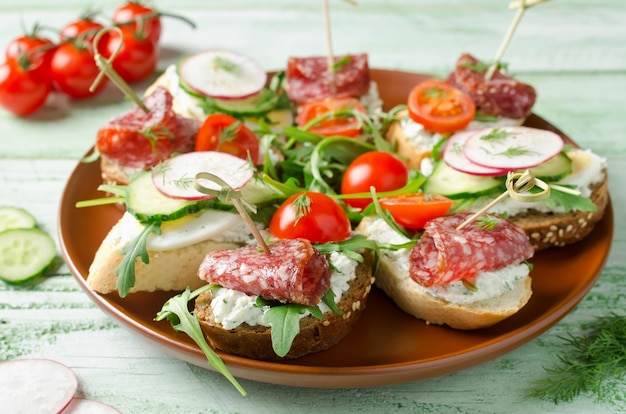 Foto frische toastsandwiches mit hüttenkäseei-rettichgurkensalami-kirschtomaten und rucola