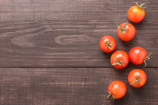 Frische Tomate auf dem braunen hölzernen Hintergrund. Ansicht von oben