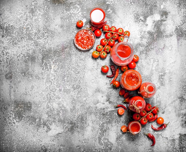 Frische Tomaten, Tomatensaft und Sauce. Auf rustikalem Tisch.