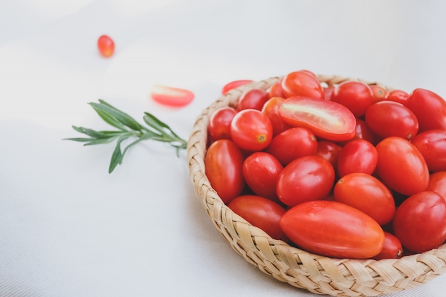 Frische Tomaten und Rosmarin auf einem weißen Hintergrund.