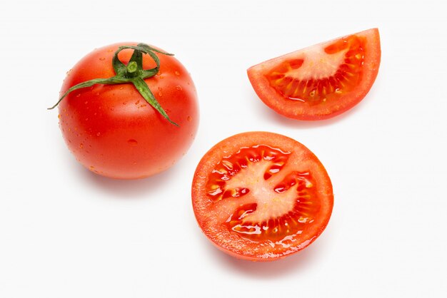 Frische Tomaten und Scheiben isoliert auf Weiß