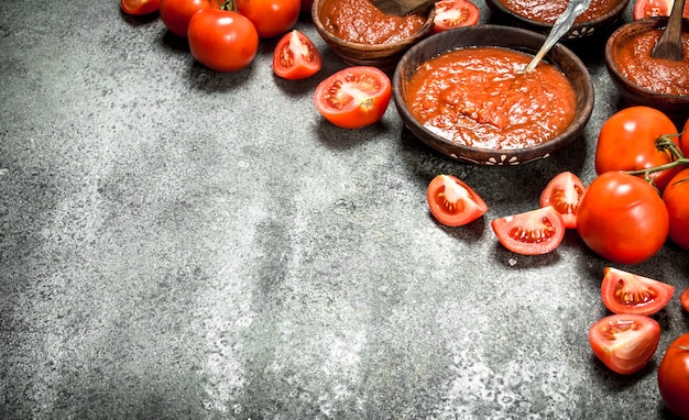 Frische Tomatensauce mit Gewürzen. Auf rustikalem Hintergrund.