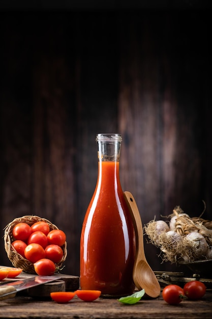Frische Tomatensauce und Saft auf einem hölzernen Hintergrund