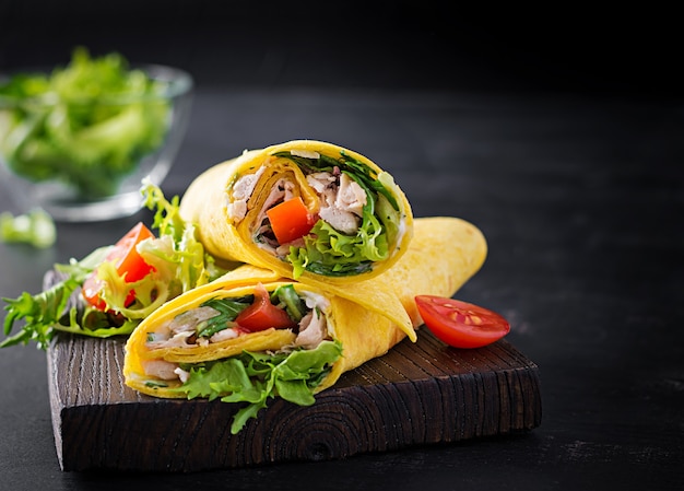 Frische Tortilla Wraps mit Huhn und frischem Gemüse auf Holzbrett. Hähnchen-Burrito. Mexikanische Küche. Speicherplatz kopieren