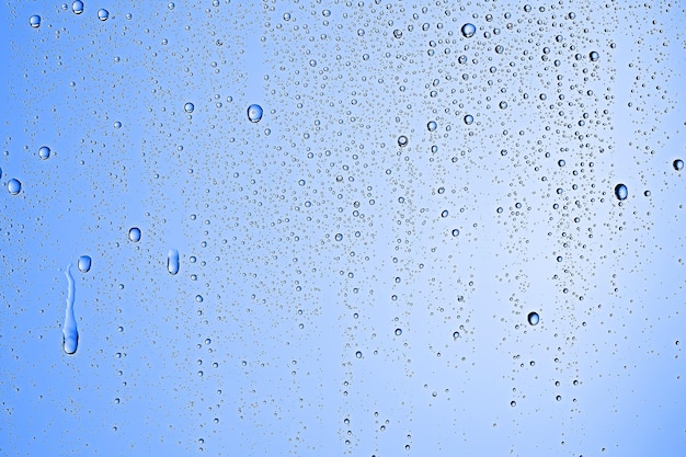 frische Tropfen Hintergrund blaues Glas / nasser regnerischer Hintergrund, Wassertropfen transparentes Glas blau