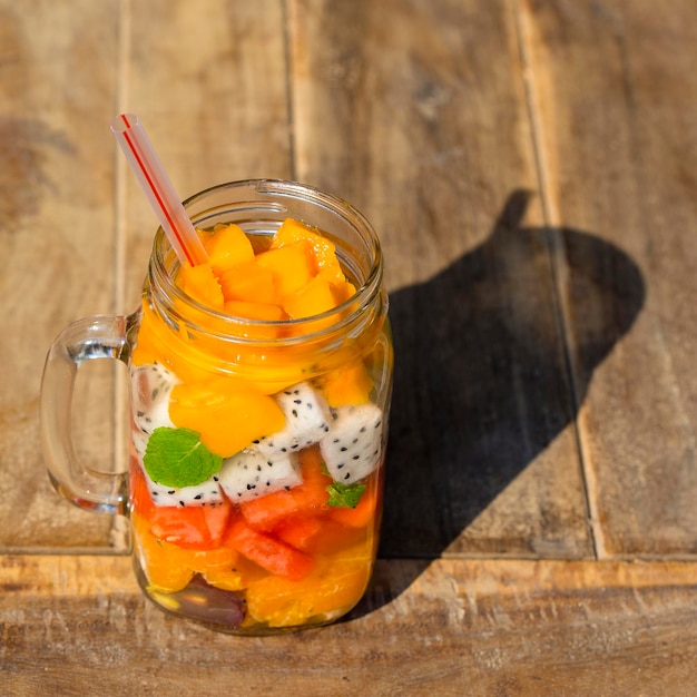 Frische tropische Früchte, Trauben, Mango, Wassermelone, Orange und Pitahaya im Glasbecher, gesundes Frühstück, Gewichtsverlust-Konzept, Thailand aus nächster Nähe