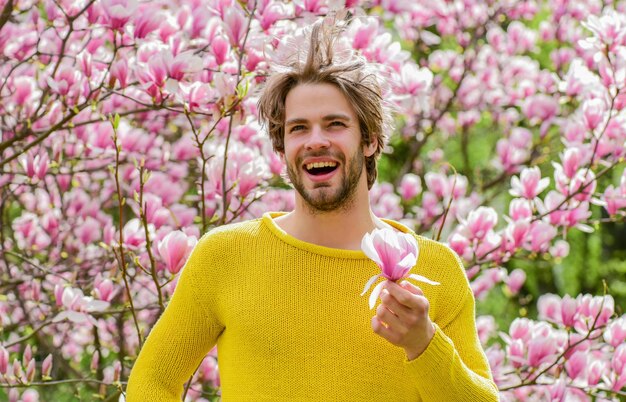 Frische und Erwachen Frühlingsinspiration Freude am Frühling Mann blüht Hintergrund Schönheit des Frühlings Moderner Hipster genießt Blüte Frühlingskonzept Kerl entspannen sich im Blumenpark Botanischer Garten