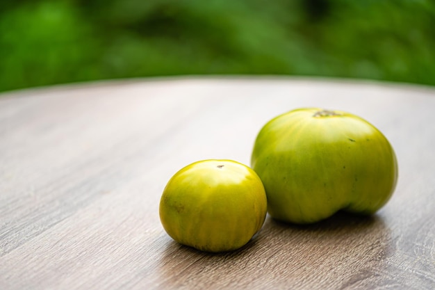 Frische und köstliche Tomaten grüner Sorte auf einem Holztisch in der Nähe