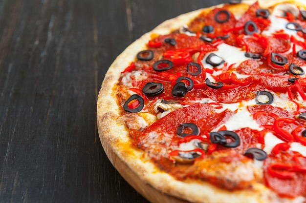 Frische und leckere italienische Pizza auf einem Holztisch