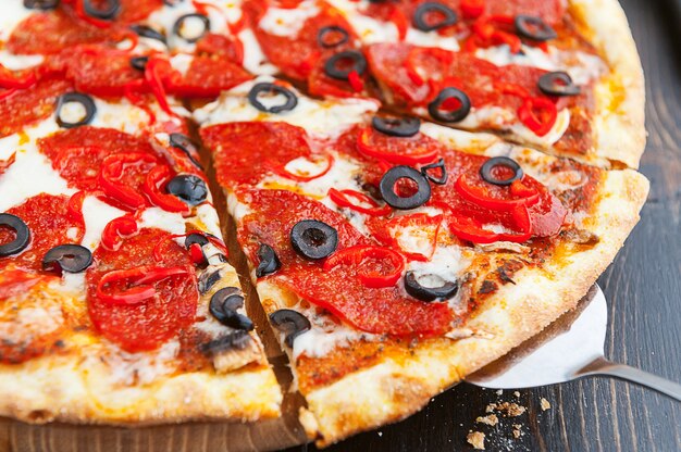 Frische und leckere italienische Pizza auf einem Holztisch