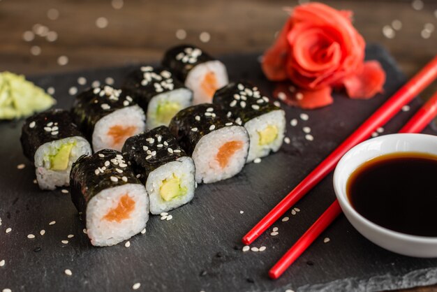 Foto frische und leckere sushi auf dunklem hintergrund.