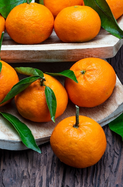 Frische und rohe Mandarinen mit grünen Blättern