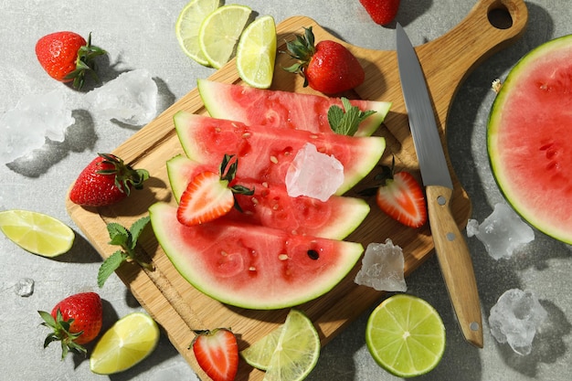 Frische und saftige Früchte mit Eis auf grauem strukturiertem Hintergrund