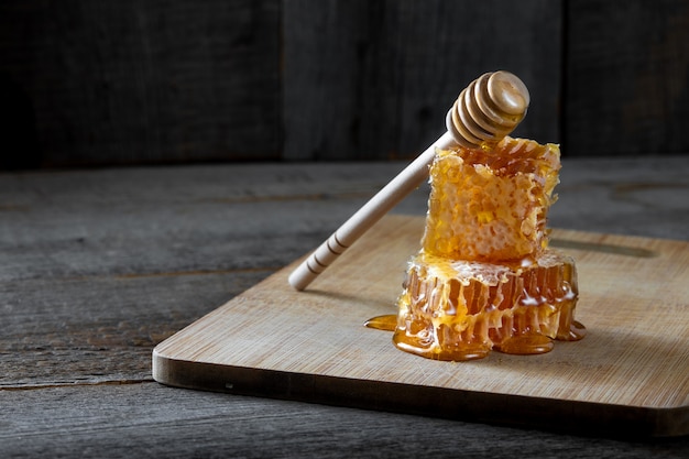 Frische wabenstücke mit honig und einem holzstab