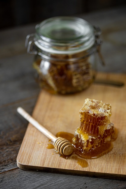 Frische Wabenstücke mit Honig und einem Holzstab