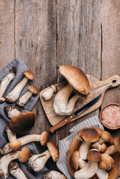 Foto frische wald-boletus-pilze auf hölzernem hintergrund top-view kopierraum herbsternte-konzept frisch gepflückte porcini-pilze im korb